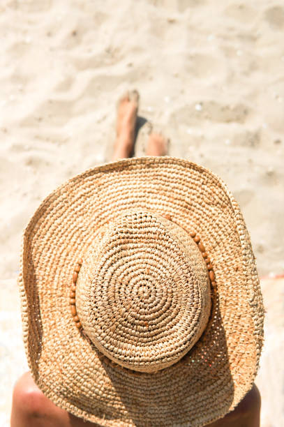 istock tanning woman wearing sun hat at the beach 1325468490