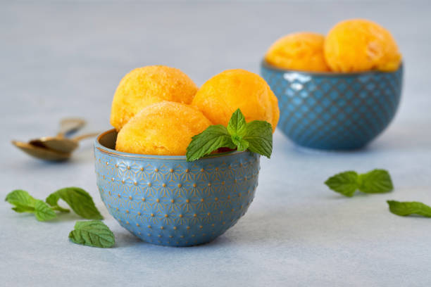 istock Yellow ice cream sorbet in blue ceramic bowl. Closeup 1325470251