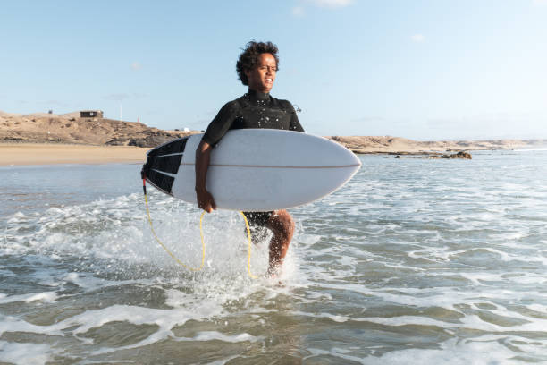 istock Young african malagasy surfer running to the waves 1325470317