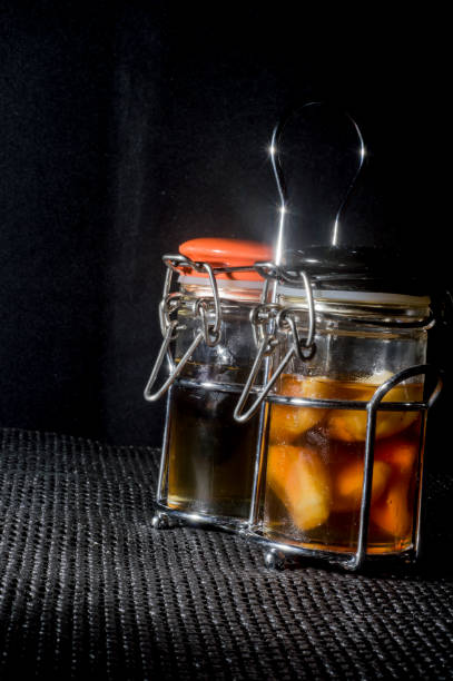 istock garlic being matured in a glass with bee honey on a black background,copy space 1325470636