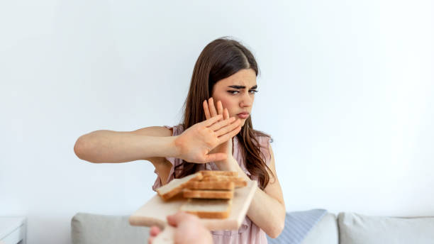 woman refusing to eat white bread. - gluten allergy imagens e fotografias de stock