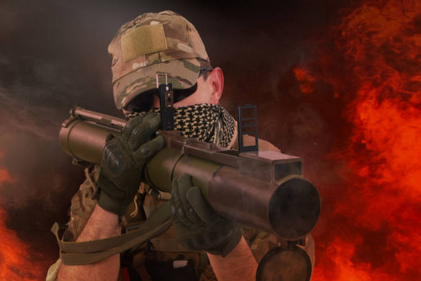 istock Private Military Contractor firing RPG (rocket propelled grenade) - soviet bazooka type grenade launcher. Flame and smoke on background. 1325470822