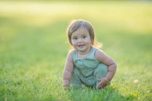 istock Happy baby playing in the grass 1325472087