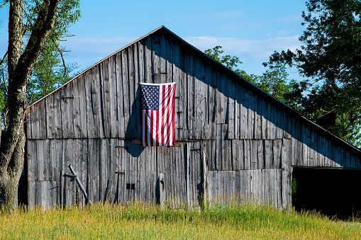 Old weathered barn with hanging American flag
