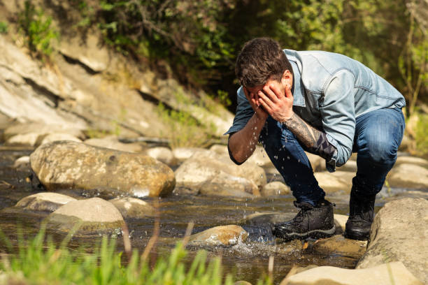 istock young caucasian man refreshing at stream and washing his face with water 1325485417