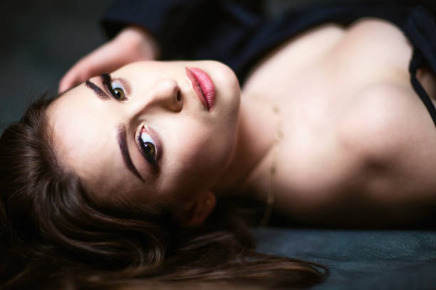 Portrait of a young beautiful black haired woman lying on back