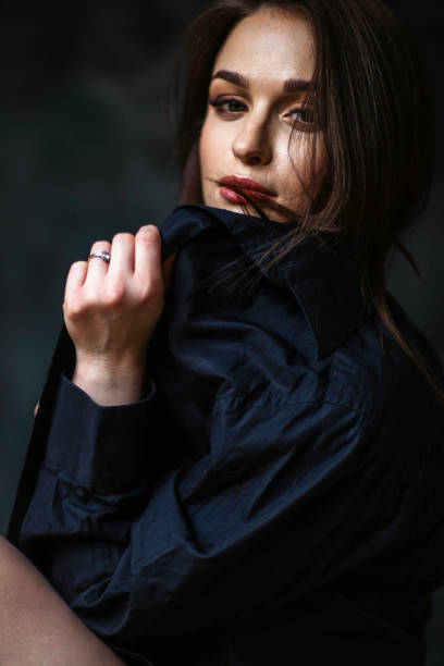 Portrait of an attractive black haired woman in black male shirt