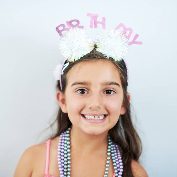 scatto di un'adorabile bambina che festeggia il suo compleanno - elementary age focus on foreground indoors studio shot foto e immagini stock