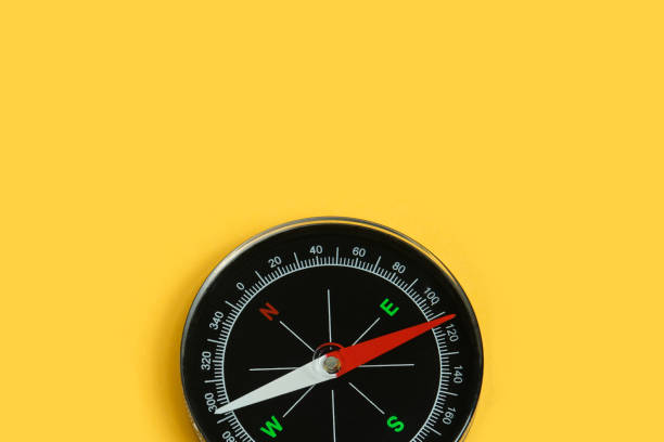 istock Top view single black compass isolated on yellow background. 1325493677