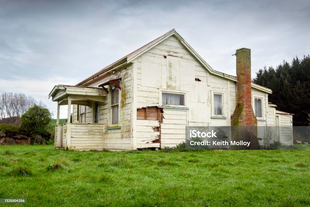 Derelict farm house Old dilapidated farm house in green grassy field. House Stock Photo