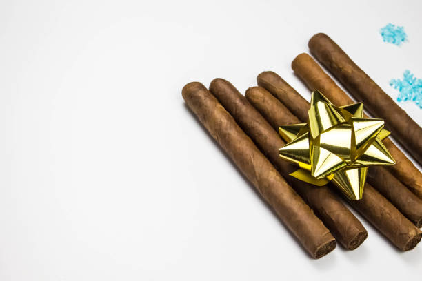 istock Cigars as a gift on white background. Cigars with gold bow. 1325504881