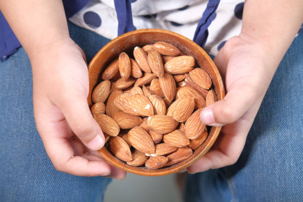istock close up child hand holding a bowl on almond 1325509924
