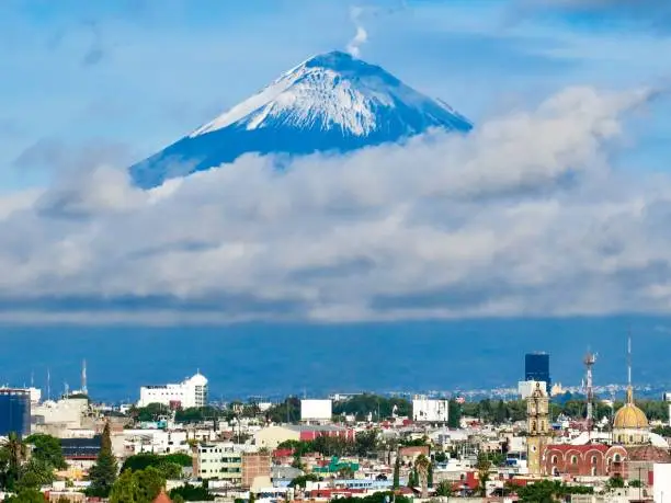 Popocatépetl (“smoking mountain”), an active volcano and he second highest peak in Mexico dwarfs the city of Puebla.