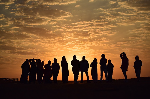 Silhouette of a group of women at sunrise. Madinah, Saudi Arabia, October 9, 2020.