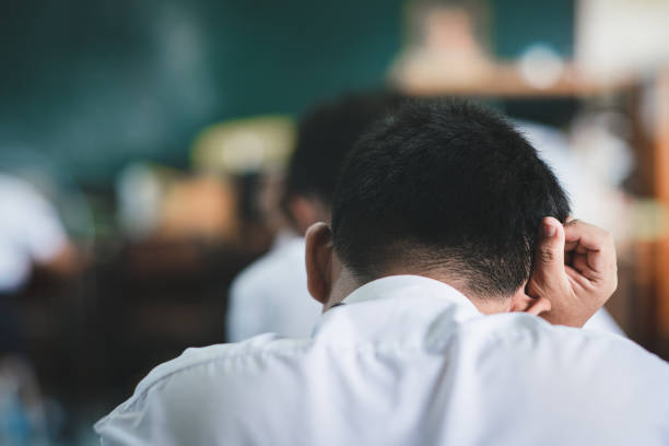Students taking exam with stress in school classroom stock photo
