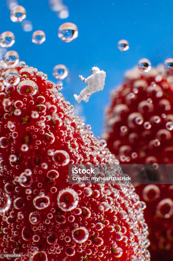 Astronauts in fizzy ocean A tiny astronaut explores a strange new world of strange colorful structures submerged in a fizzy ocean. Malaysia Stock Photo