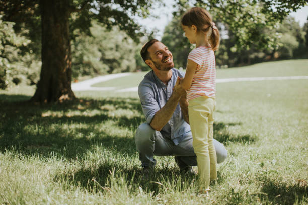 istock Father with daughter having fun on the grass at the park 1325521478