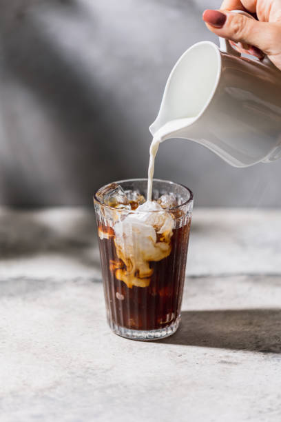Coffe swirl Person pouring milk in the coffee iced coffee stock pictures, royalty-free photos & images
