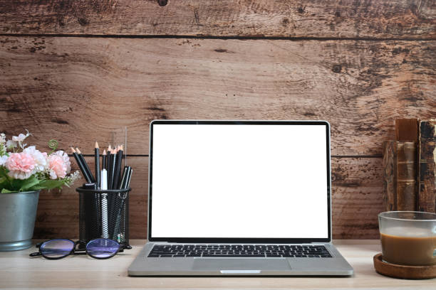 istock Laptop computer with blank screen, coffee cup and vintage books on  wooden table. 1325525694