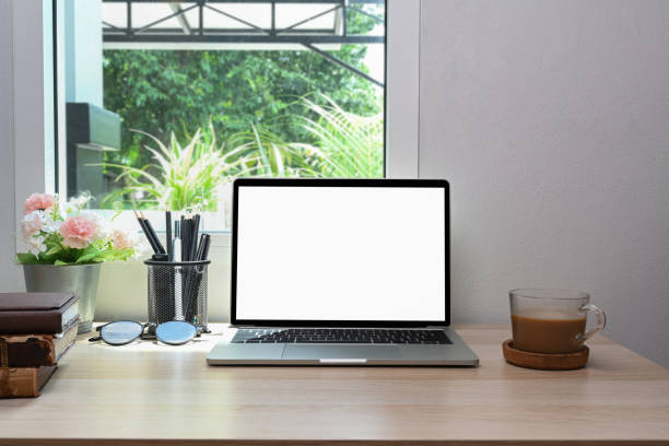 istock Mock up laptop computer with white screen on wooden table in living room. 1325525744