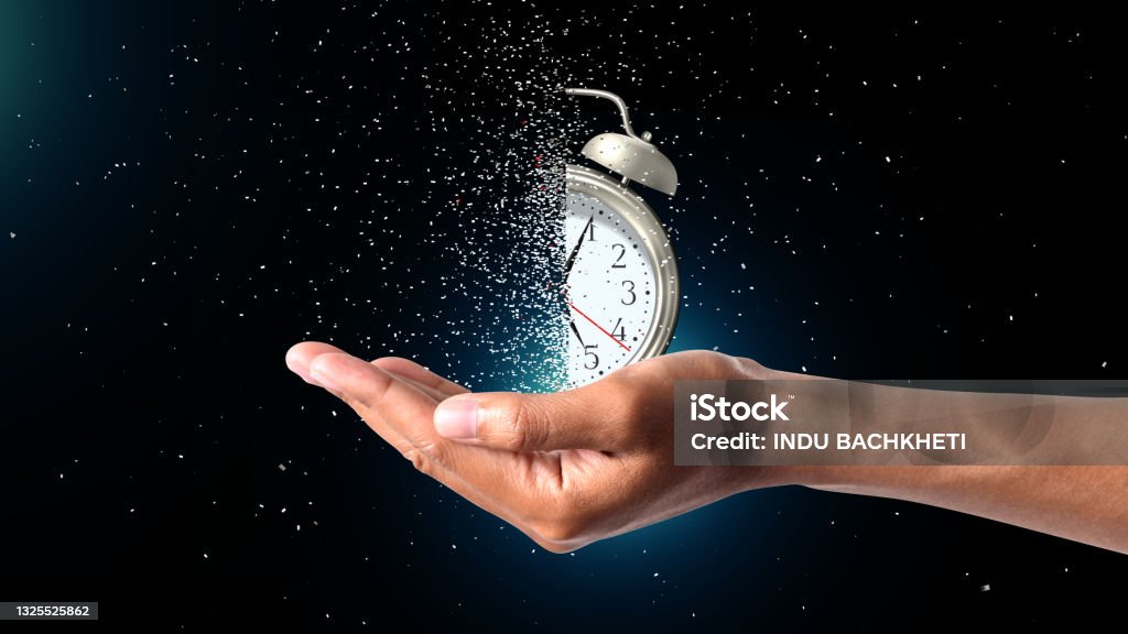 Clock Dispersing in hand Concept of passing away, the clock breaks down into pieces. Hand holding analog clock with dispersion effect Time Stock Photo