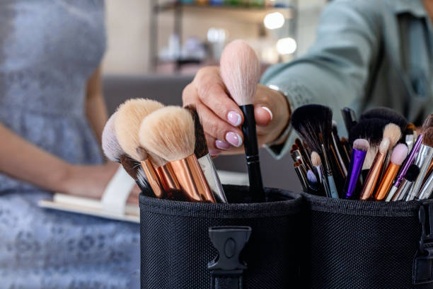 istock Closeup female makeup artist hands taking brush for applying cosmetics explaining to client 1325526754