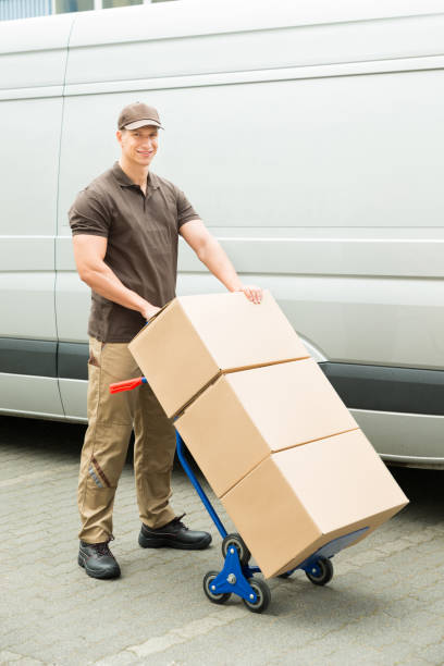 istock Delivery Man Holding Trolley With Cardboard Boxes 1325529845