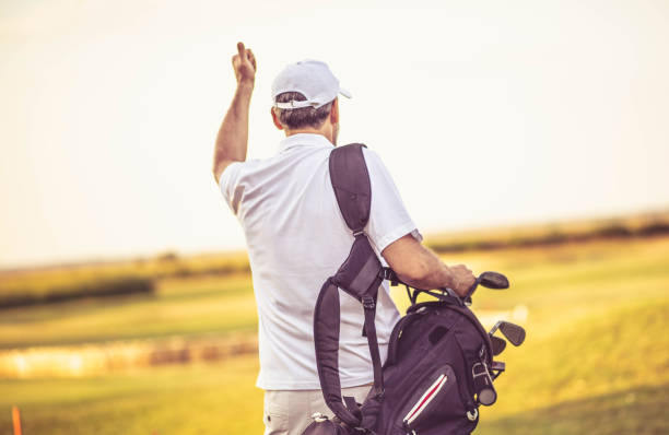 istock Senior golfer walking on golf court with bag. 1325530161