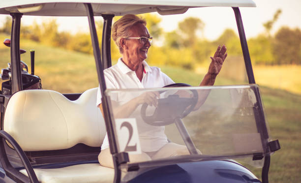 istock Senior woman driving golf car. 1325530511