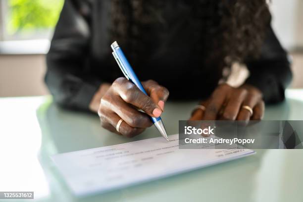 African Woman Writing Check Stock Photo - Download Image Now - Check - Financial Item, Writing - Activity, Women