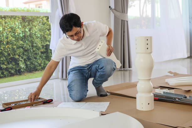 istock Man assembling white table furniture at home 1325534092