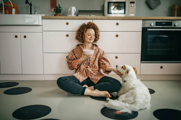 bella rossa che mangia la colazione sul pavimento della cucina - eating women breakfast cereal foto e immagini stock