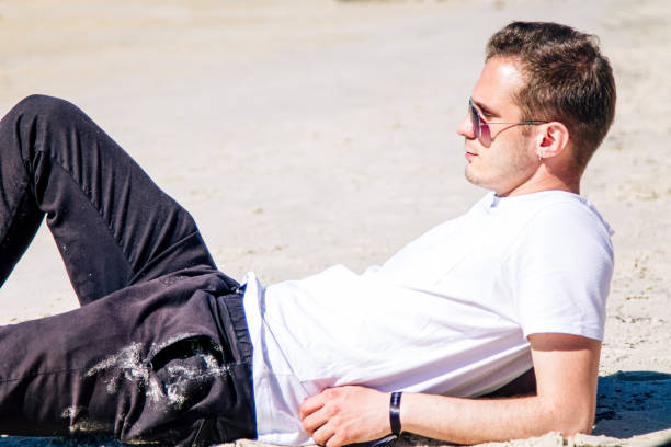 istock relaxed man lying on the beach sand 1325540758