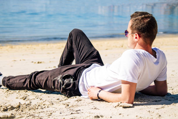istock relaxed man lying on the beach sand 1325540772
