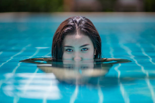istock Beautiful woman floating in a swimming pool. 1325546274