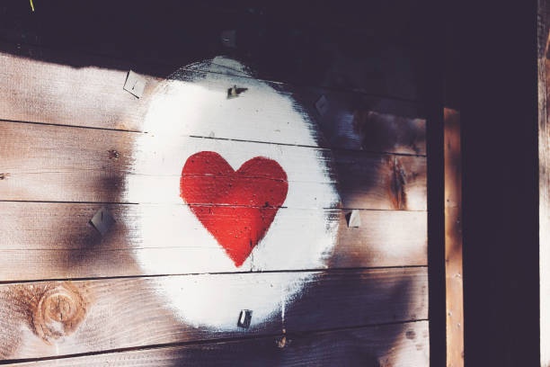 Image of a bright red heart symbol surrounding white on a wooden plaque