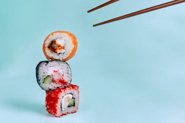 istock balancing rolls on top of each other and chopsticks on a blue background 1325547038