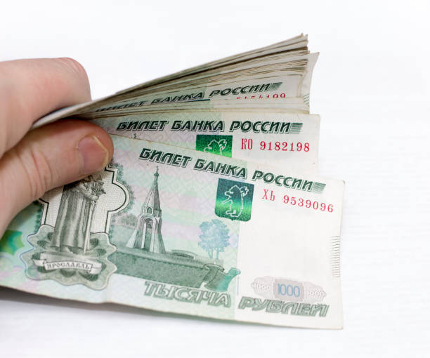 Man holding scattered russian 1000 rubles banknotes closeup isolated Man holding scattered russian 1000 rubles banknotes closeup isolated on the white background golden ring of russia photos stock pictures, royalty-free photos & images
