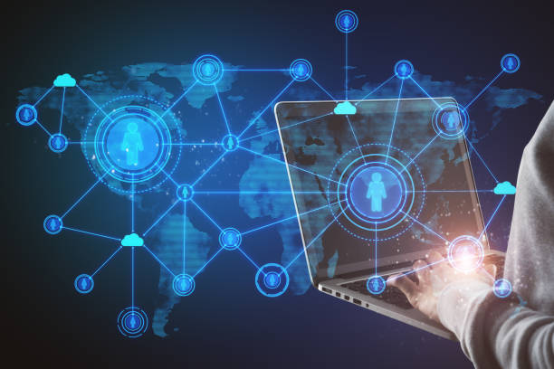 istock Close up of hands using laptop with abstract social network hologram on blue background. Recruiting and cloud technology concept. 1325549850
