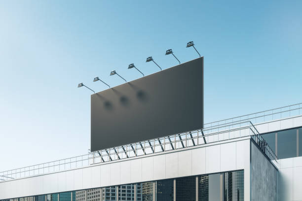 istock Empty black billboard with on shopping mall exterior. Blue sky background. Mock up place for your advertisement. 3D Rendering. 1325549935