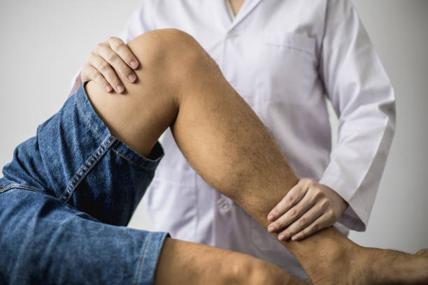 A professional physiotherapist is stretching the patient's legs, the patient has muscle dysfunction due to hard work, most often an office worker who has problems sitting for long periods of time. un fisioterapeuta profesional está estirando las piernas del paciente, el paciente tiene disfunción muscular debido al trabajo duro, la mayoría de las veces un oficinista que tiene problemas para sentarse durante largos períodos de tiempo.