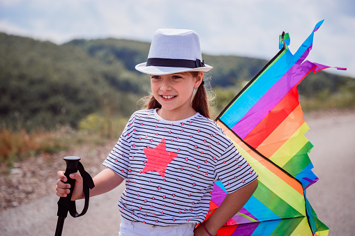 Joyful young kid with aa kite toy in nature