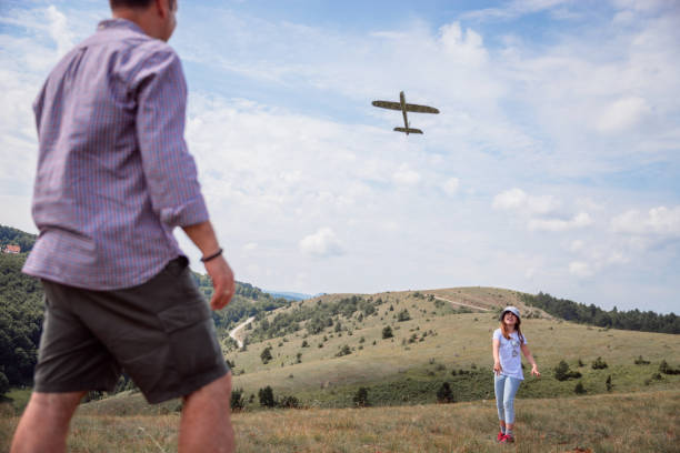 istock Father and daughter flying toy plane 1325557139