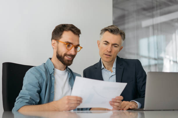 istock Businesspeople using laptop, talking, communication, planning startup, working in office. Two business colleagues in meeting 1325565902