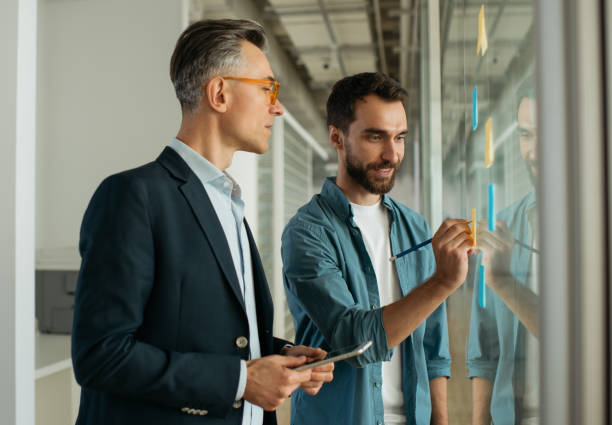 istock Business people meeting planning start up using sticky notes working in modern office. Colleagues talking, discussing ideas, communication together at workplace, selective focus 1325565948