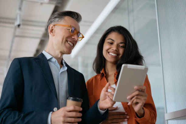 gli uomini d'affari che utilizzano il progetto di start-up di pianificazione digitale dei tablet, condividono idee sul posto di lavoro. colleghi di successo che lavorano in un ufficio moderno. concetto di incontro di lavoro - arancione foto e immagini stock