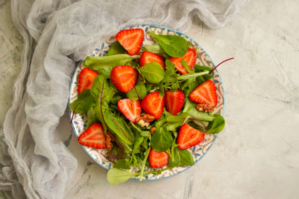 istock salad with strawberries, nuts on a concrete background 1325568124