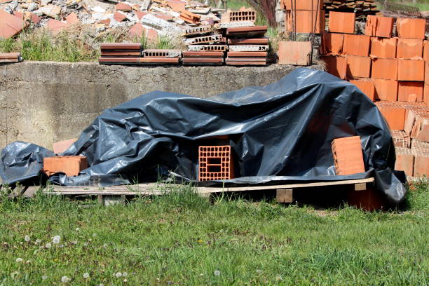 istock Piles of red building blocks and bricks mixed with construction material and other junk next to old concrete foundation 1325570176