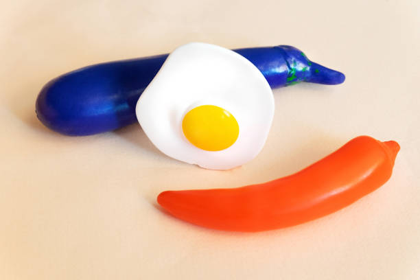 istock Scrambled eggs stand between red pepper and eggplant on a beige background. 1325571126