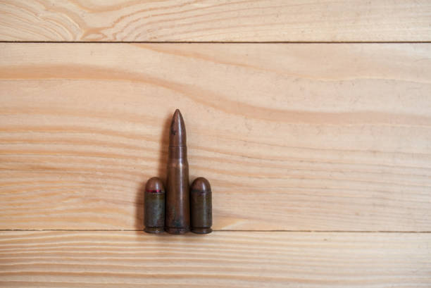 Bullets on a wooden background. Three different caliber bullets together on a wooden background. Military concept.